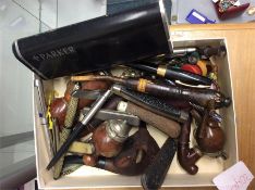 A box containing pen knives, pens and pipes.