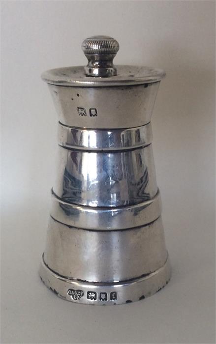 An unusual churn shaped pepper grinder of typical
