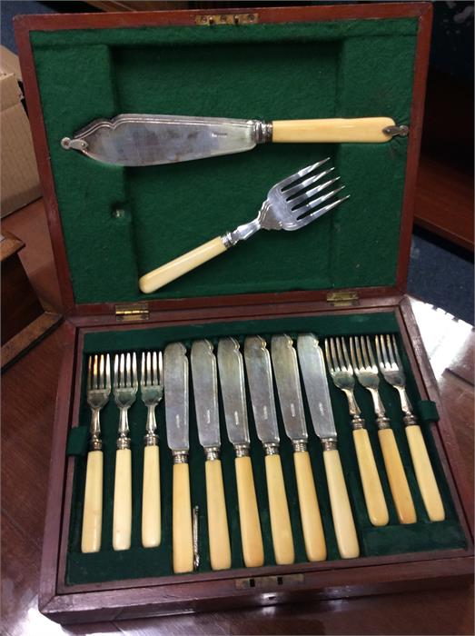 A mahogany box containing fish cutlery.