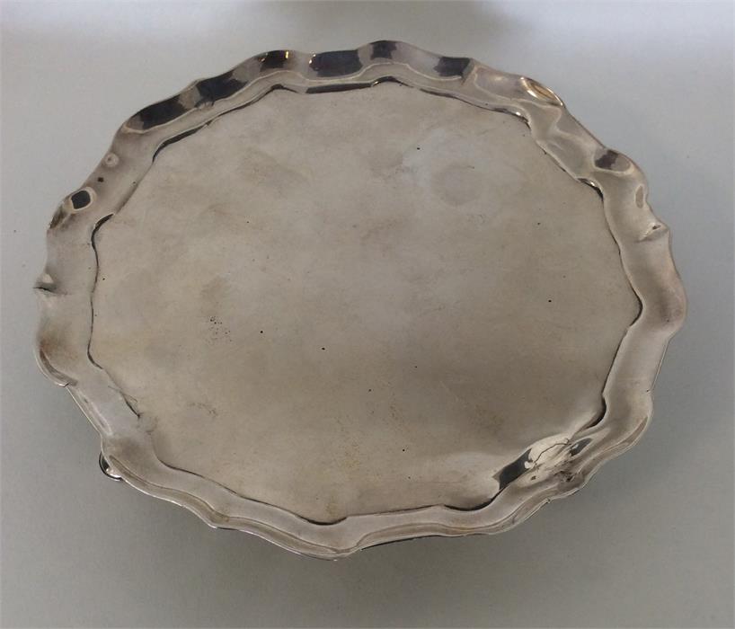 A George II circular silver waiter with wavy edge