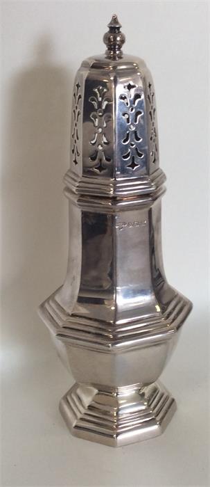 A Georgian style silver caster with lift-off cover