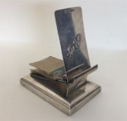 A novelty silver notepad on square base with hinge