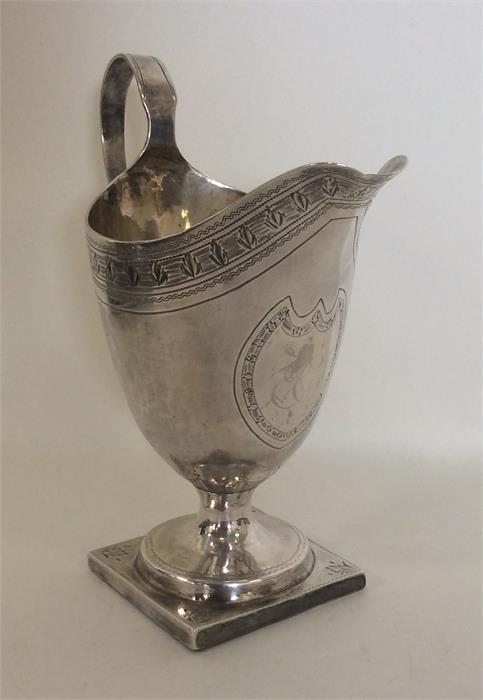 A Georgian silver helmet shaped cream jug attracti