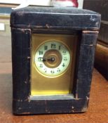 A brass carriage clock contained within a travelli