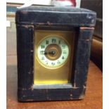 A brass carriage clock contained within a travelli