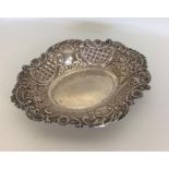 An embossed silver oval pin dish decorated with fl