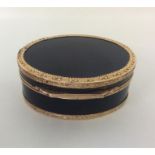 A large gold and tortoiseshell oval box decorated