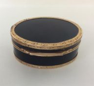 A large gold and tortoiseshell oval box decorated