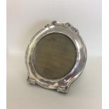 A large circular scroll top picture frame with vel