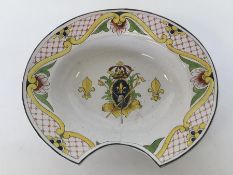 A Faience barber's bowl brightly painted with a cr