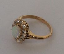An oval and opal diamond cluster ring in claw moun