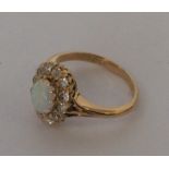 An oval and opal diamond cluster ring in claw moun