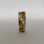 A carved ivory netsuke in the form of a robed man