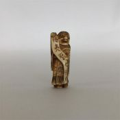 A carved ivory netsuke in the form of a robed man