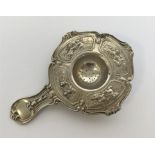 A Continental silver tea strainer heavily decorate