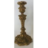 A Georgian brass candlestick heavily decorated wit