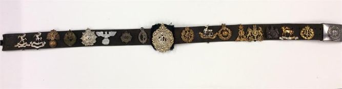 A good leather belt containing cap badges and Mili