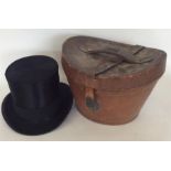 An old top hat contained within a leather case. Es