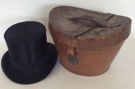 An old top hat contained within a leather case. Es