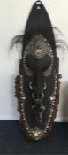 A massive tribal mask heavily decorated with shell