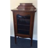 An attractive Edwardian inlaid cabinet with glass-