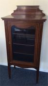 An attractive Edwardian inlaid cabinet with glass-