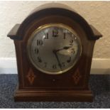 An Edwardian Mahogany dome top clock with striking