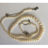 A graduated string of pearl beads with oval diamon