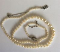 A graduated string of pearl beads with oval diamon