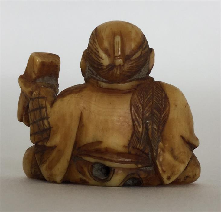 A small carved ivory netsuke in the form of a cros - Image 2 of 2