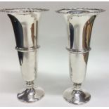 A pair of silver tapering spill vases with wavy ed