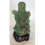 A Chinese green agate figure modelled as a seated