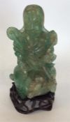A Chinese green agate figure modelled as a seated