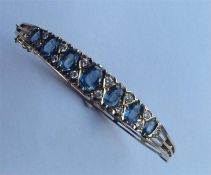 A heavy 9 carat diamond-mounted hinged bangle with