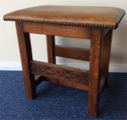 An oak carved stool with leather top. Est. £20 - £