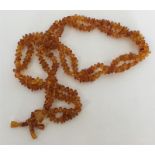 A double string of amber beads with matching tasse