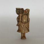 A carved ivory netsuke in the form of a bearded ma
