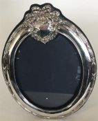 A large modern silver oval picture frame with velv