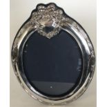 A large modern silver oval picture frame with velv