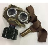 An old World War II gas mask together with a brass