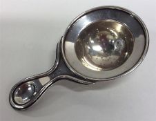 A stylish silver tea strainer with gilt interior.