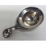 A stylish silver tea strainer with gilt interior.