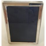A modern silver rectangular picture frame with bal