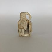 A signed carved ivory netsuke in the form of a bea