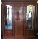 An Edwardian mahogany triple wardrobe with mirrore