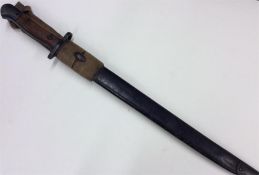 An Antique brass and mahogany-mounted bayonet. Est