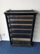 An ebony and glazed display cabinet with fitted in