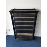 An ebony and glazed display cabinet with fitted in