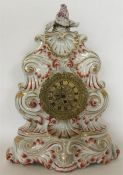 A Continental porcelain clock case moulded with le