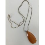 An amber teardrop pendant on silver chain. Approx.